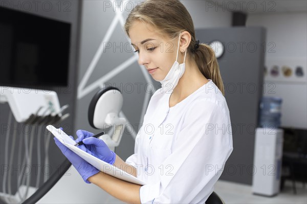 Dental assistant writing notes