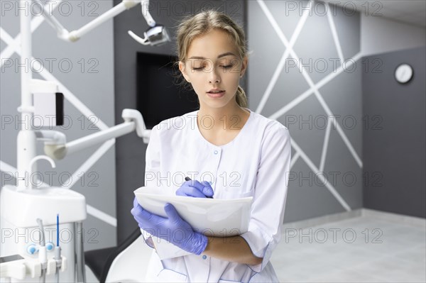 Dental assistant writing notes