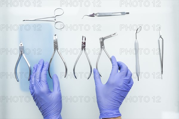 Hands of dental assistant wearing rubber gloves with dental equipment