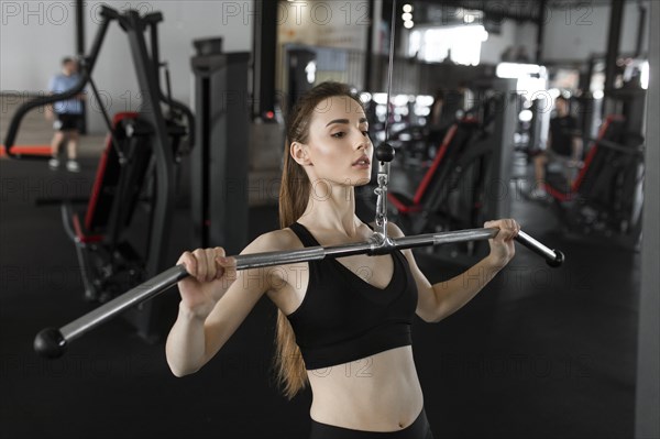 Young woman using exercise machine in gym