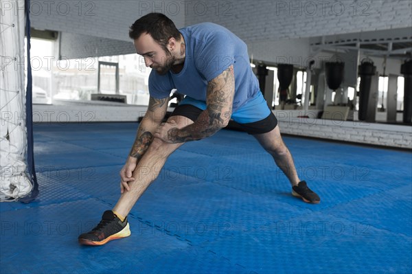 Mid adult man stretching in gym