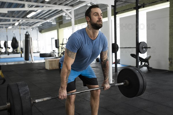 Mid adult man weight lifting in gym