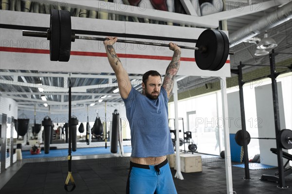 Mid adult man weight lifting in gym