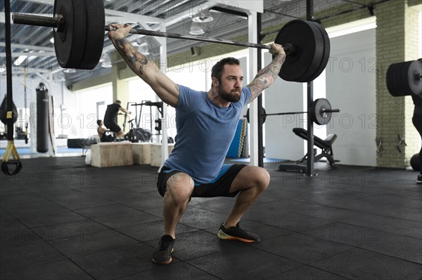 Mid adult man weight lifting in gym