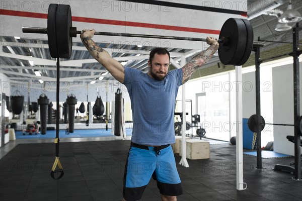 Mid adult man weight lifting in gym