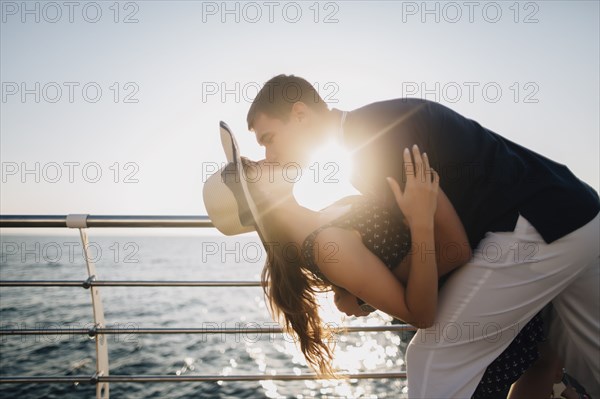 Man dipping and kissing woman on pier