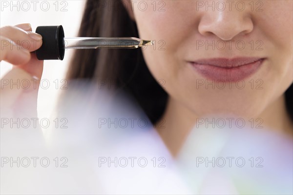 Woman with pipette of essential oil