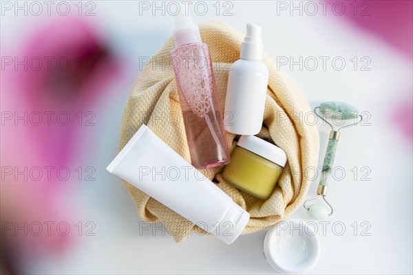 Bottles of skin care with a face massager
