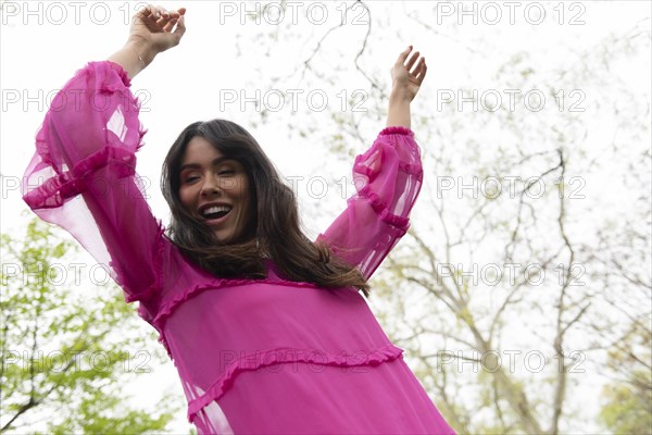 Smiling woman dancing in pink dress