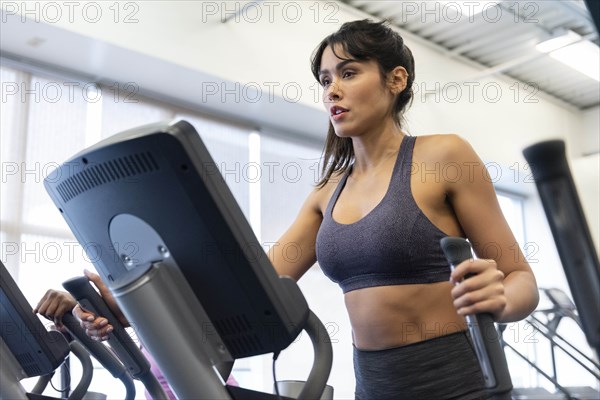 Woman exercising on elliptical machine