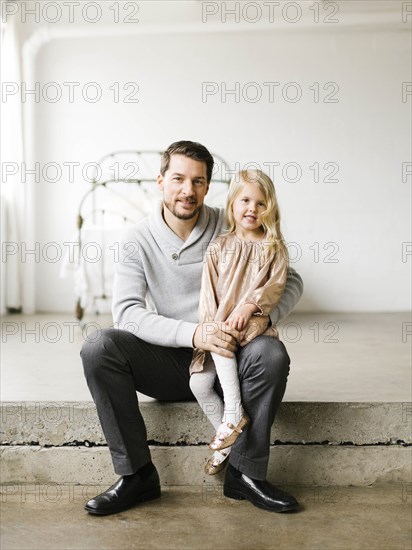 Girl sitting on her father's lap