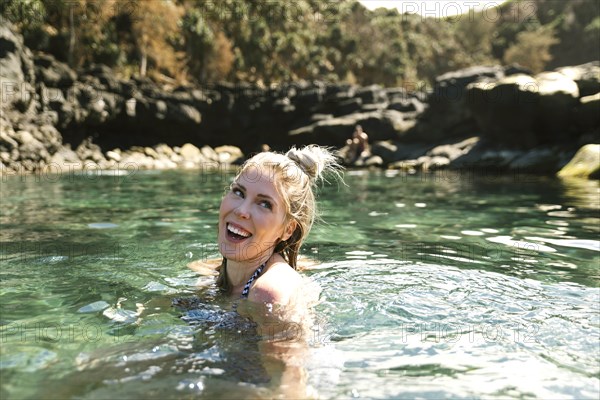 Smiling woman swimming in sea