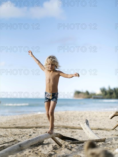 Boy balancing on driftwood