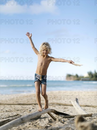 Boy balancing on driftwood