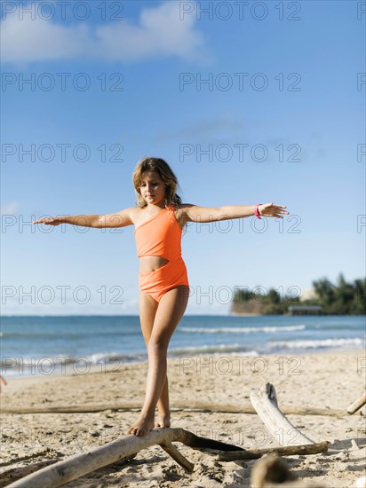 Girl balancing on driftwood