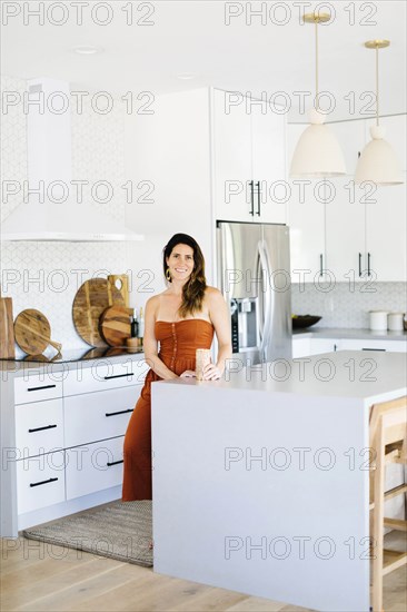 Mid adult woman smiling in kitchen