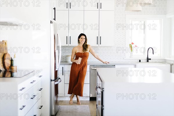 Mid adult woman smiling in kitchen