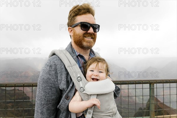 Father with his baby girl in baby carrier