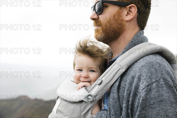 Father with his baby girl in baby carrier