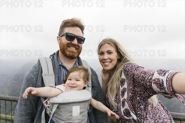 Parents with their baby girl in baby carrier