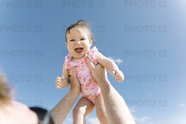 Father holding his baby girl aloft