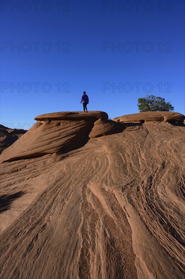 Woman walking on smooth rock in Monument Valley, Arizona, USA