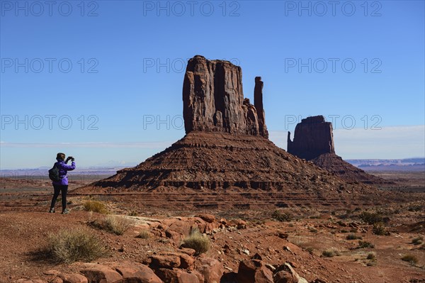 Woman photographing butte in Monument Valley, Arizona, USA