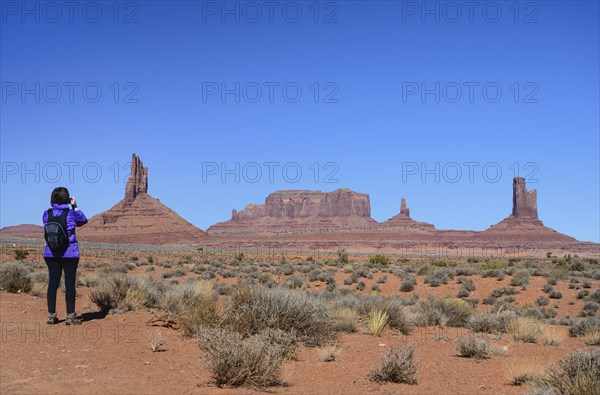 Woman wearing backpack by buttes in Monument Valley, Arizona, USA