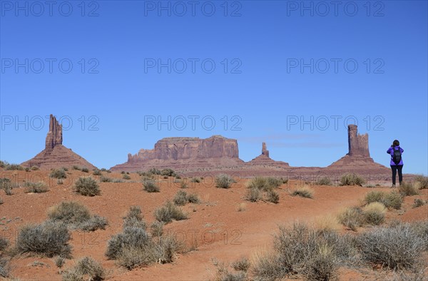 Woman wearing backpack by buttes in Monument Valley, Arizona, USA