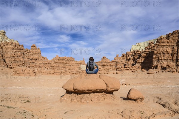 Woman sitting on rock in Goblin Valley State Park, Utah, USA