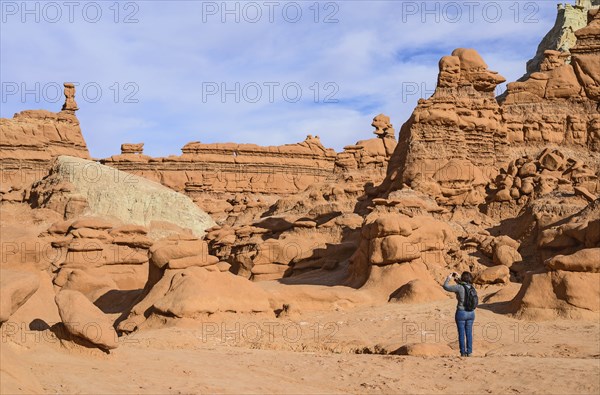 Woman photographing hoodoos in Goblin Valley State Park, Utah, USA