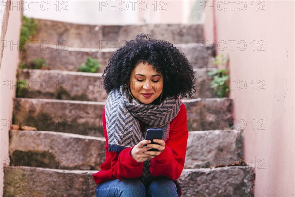 Young woman with smart phone sitting on steps