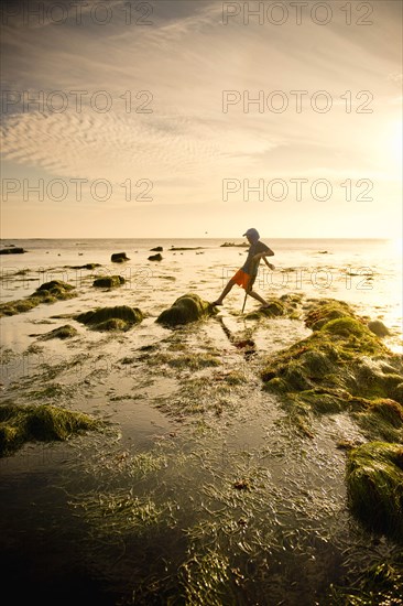 Teenage boy exploring tide pools in La Jolla, California