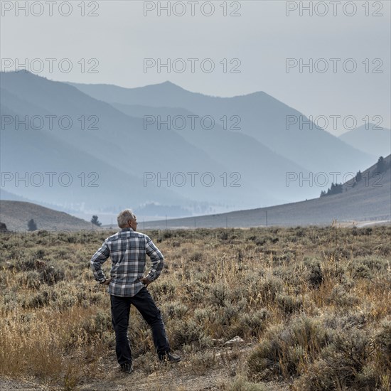 Senior man standing in field by mountains in Sun Valley, Idaho, USA