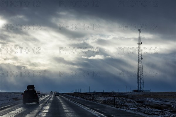 Country road with snow under overcast sky