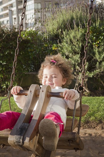 Girl on swing in city park