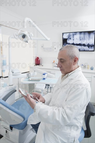 Dentist using digital tablet in dentist's surgery