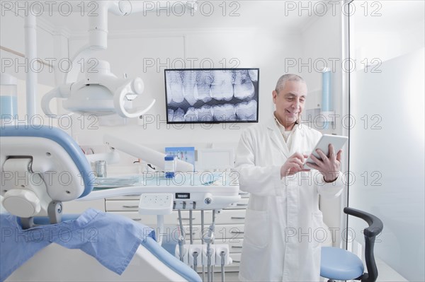 Dentist using digital tablet in dentist's surgery