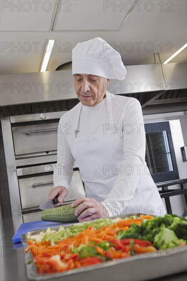 Chef slicing squash in commercial kitchen