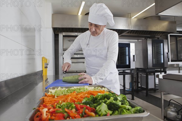 Chef slicing squash in commercial kitchen