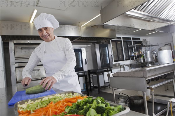 Chef slicing squash in commercial kitchen