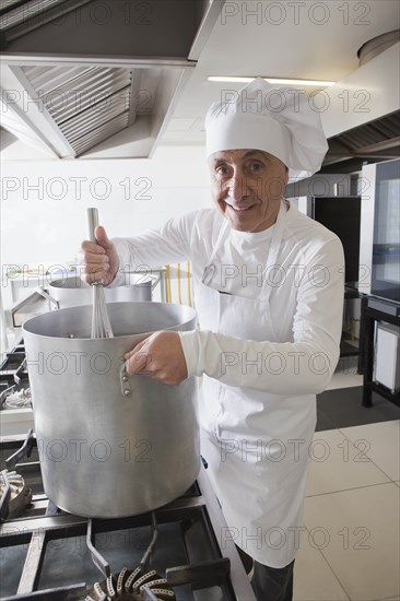 Chef using whisk in pot