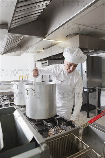 Chef using whisk in pot