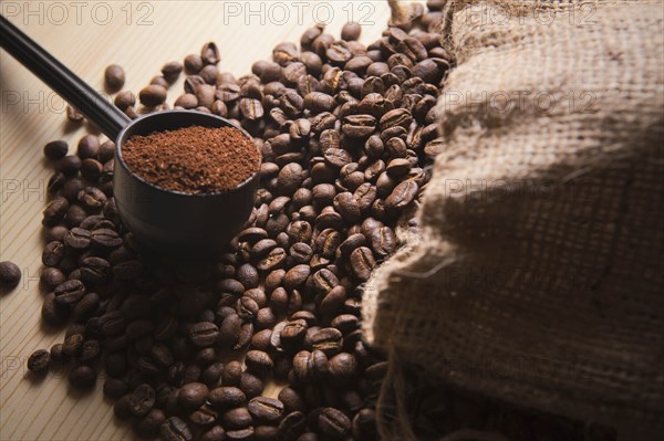 Portafilter holding ground coffee on roasted coffee beans