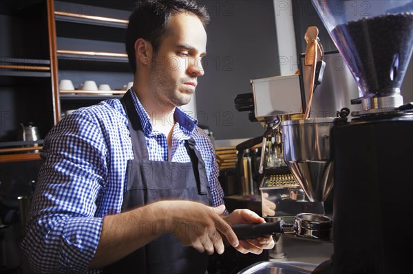 Barista collecting ground coffee in portafilter