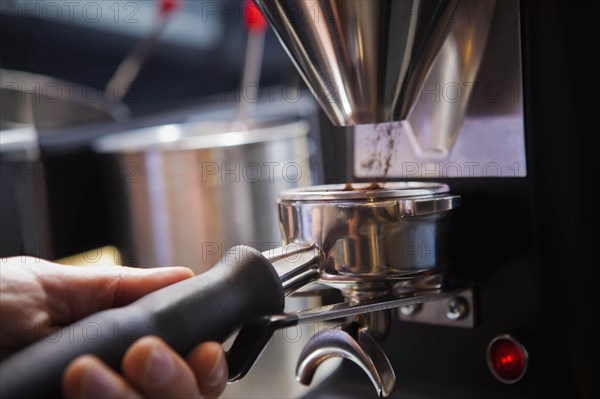 Barista collecting ground coffee in portafilter