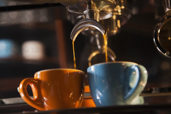 Coffee pouring from portafilter into coffee cups