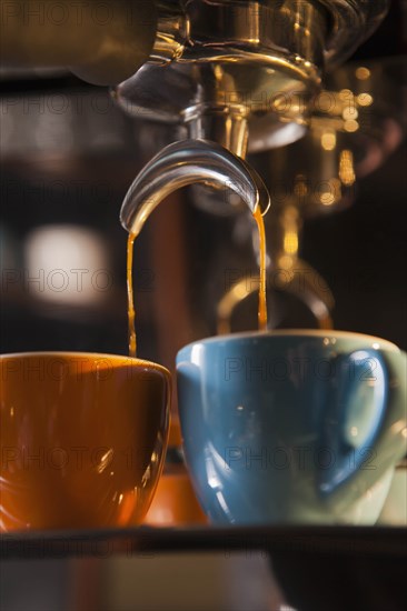 Coffee pouring from portafilter into coffee cups