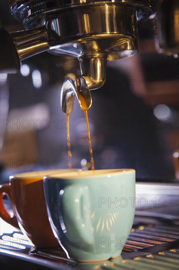 Coffee pouring from portafilter into coffee cups