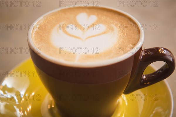 Coffee in yellow cup with heart shape